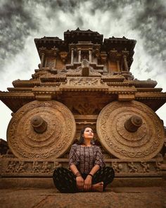 a woman sitting on the ground in front of a building