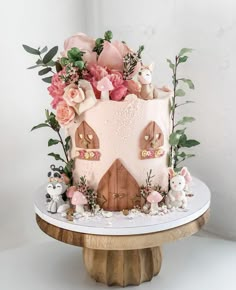 a cake decorated with flowers and animals on a table