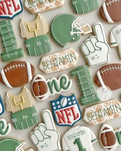 decorated cookies are arranged in the shape of american footballs and numbers, including one for each team