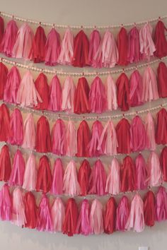 pink and red tissue tassels hanging on the wall