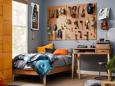 a bedroom with a bed, desk and various items hanging on the wall above it