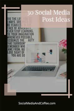 a laptop computer sitting on top of a desk next to a vase with pink flowers