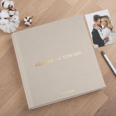 a wedding album with the words amanda and edward written on it next to cotton flowers