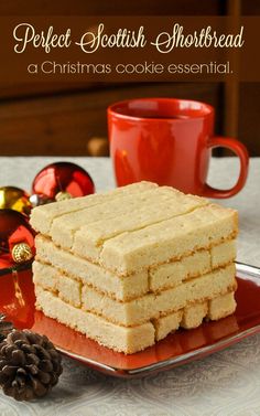 a stack of shortbreads sitting on top of a red plate next to a cup of coffee