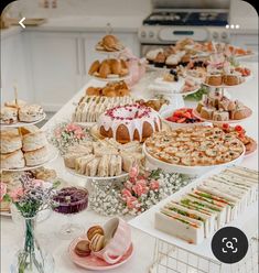 a table filled with lots of different types of cakes and pastries on it's sides