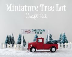 a miniature red truck with christmas trees in the background and a sign that says miniature tree lot craft kit