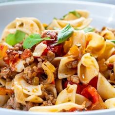 a white bowl filled with pasta and meat