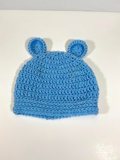 a crocheted blue hat with ears on it