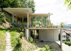 the house is built on top of a hill and has plants growing out of it