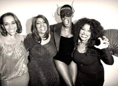 a group of women standing next to each other in front of a wall with masks on