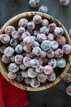 a wooden bowl filled with powdered berries on top of a table