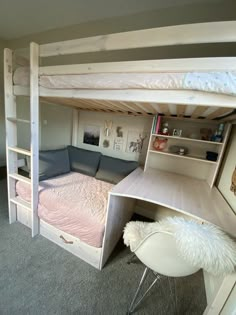 a bunk bed with desk underneath it in a room that has carpeted flooring