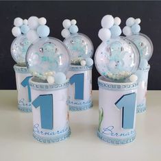 three birthday candles with balloons in them on a table