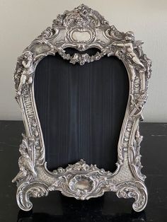 an ornate silver frame sitting on top of a table