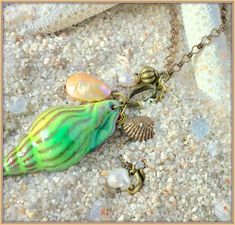 "* If you love the sea, you'll love this Nautical Necklace * A richly enameled Brass Pendant in the form of a True Tulip Seashell, 2\" (50mm) in length, in a gorgeous shade of Sea Green with Sandy Brown highlights * Long, interesting Chain Necklace, available in several lengths; please select your favorite * All Natural Pearls, both Freshwater and Coin Pearl, dangling with Bronze Charms * This beautiful Beach Necklace will be gift wrapped in a lovely gift box. Thank you for visiting my shoppe! N Green Shell Jewelry For Beach, Handmade Beachy Green Jewelry, Green Shell Bohemian Jewelry, Green Shell-shaped Jewelry For Gifts, Green Shell Jewelry For Gifts, Green Shell Necklace For Gift, Unique Green Necklace For The Beach, Bohemian Green Shell Necklace Gift, Green Shell Jewelry As A Gift