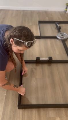 a woman is doing something on the floor with her hands and legs bent over it