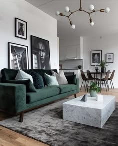 a living room filled with furniture and pictures hanging on the wall above a coffee table