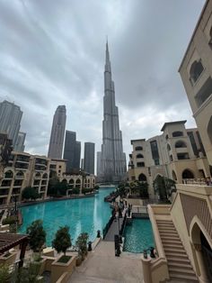 the burj tower towering over the city is seen in this view from an outdoor swimming pool