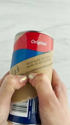 a person holding up a can of food with the word original on it's side