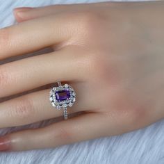 Details: Materials: Amethyst Gemstone, White Zircons, S925 Sterling Silver Plated with 18K White Gold Color: Purple Shape: Retangular Size: Adjustable and fitable for all Descriptions: This elegant ring has a 7x5mm amethyst and forty-four white zircons. Other than the stones, the ring is made out of S925 sterling silver plated with 18K white gold. A ring of small zircons outlined the amethyst. A circle zircon alternates with an oval zircon to create a pattern for the second outline of the ring. Dazzling Amethyst Ring Gift, Dazzling Amethyst Ring As A Gift, Dazzling Amethyst Gift Ring, Luxury Gemstones With Halo Setting For Gift, Exquisite Amethyst Jewelry With Center Stone, Exquisite Amethyst Ring With Prong Setting For Anniversary, Exquisite Purple Jewelry With Center Stone, Exquisite Cubic Zirconia Gemstones For Anniversary, Amethyst Ring With Diamond For Gift