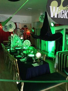 a room filled with tables and chairs covered in green lights for halloween party guests to sit at