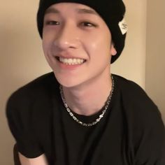 a young man wearing a black hat and smiling