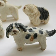 four small ceramic dogs on a white surface