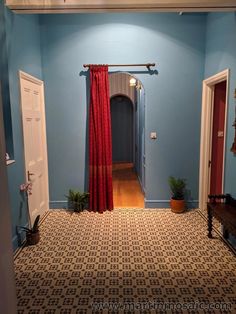 an empty hallway with blue walls and red curtains