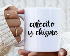 a person holding a coffee mug with the words cafeto y chisme on it