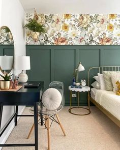 a bedroom with green paneled walls and white bedding, desk, chair and mirror