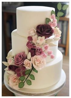 a three tiered white cake with flowers on top