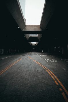 an empty street with yellow lines on the side and a skylight above it that is lit up