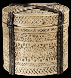 an intricately carved wooden box with leather straps