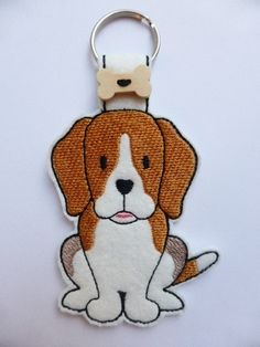 a brown and white dog sitting on top of a key chain