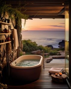 a large bath tub sitting on top of a wooden floor next to a stone wall