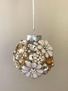 a christmas ornament hanging on a wall with beads and other things in it