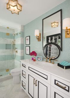 a bathroom with blue and white wallpaper and gold accents