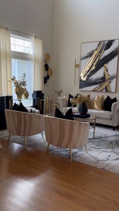 a living room filled with furniture and a painting on the wall next to a window