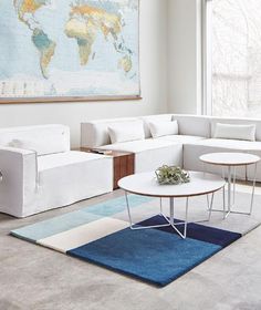 a living room filled with furniture and a large map hanging on the wall above it