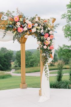 a wedding arch with flowers and greenery on it