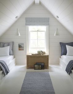 a bedroom with two beds and a rug on the floor in front of a window