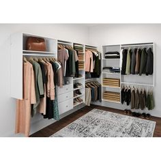 a white closet filled with lots of clothes and other items on shelves next to a rug