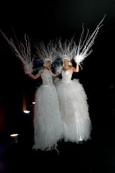 two women in white dresses standing next to each other