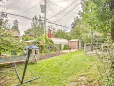 a backyard with a swing set and playground in the back yard, surrounded by trees