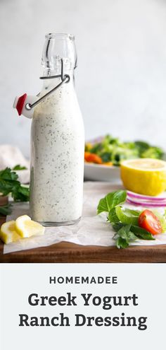 homemade greek yogurt ranch dressing in a glass bottle on a wooden cutting board