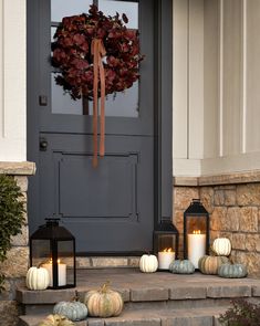 the front door is decorated with pumpkins and lanterns