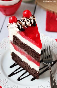 a piece of cake with red, white and black frosting on a plate next to a fork