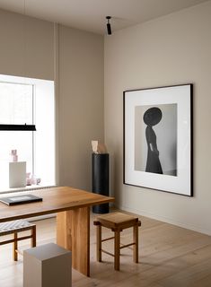 a wooden table sitting in front of a window next to a laptop computer on top of a desk