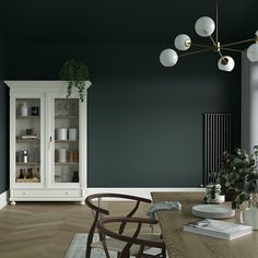 a dining room with dark green walls and white furniture