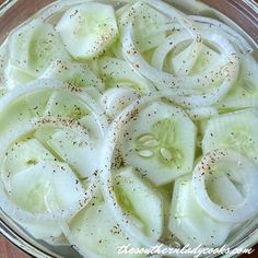 a bowl filled with sliced up onions and seasoning next to a wooden table top